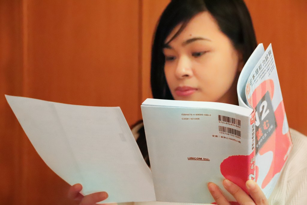 Girl reviewing with a book and handout